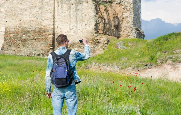 Bonito homem, turista, com mochila tirando fotos em um smartp — Fotografia de Stock