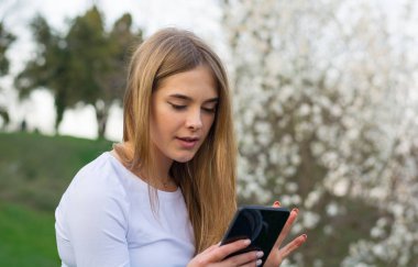 Genç güzel kız öğrenci uzun sarı saçlı oturur ile bir ta