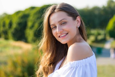 Genç güzel gülümseyen, beyaz pıhtı çıplak omuzlu kadın