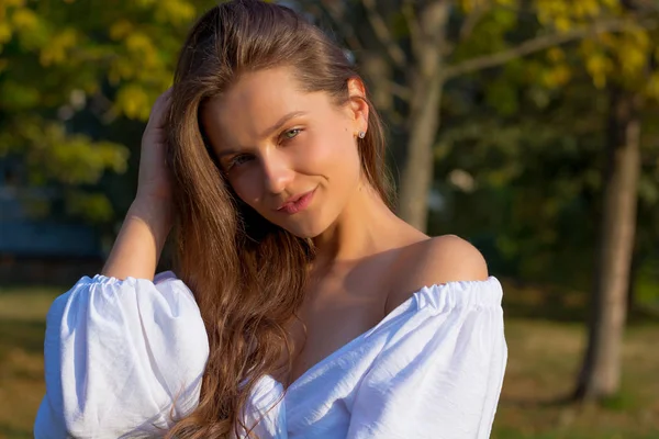 Junge schöne lächelnde Frau mit nackten Schultern in weißem Tuch — Stockfoto