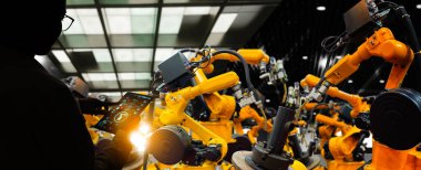 Fabrika Kadın Endüstriyel Mühendisi akıllı fabrika endüstrisinde otomasyon robot silah makinesiyle çalışıyor..