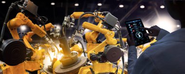 Fabrika Kadın Endüstriyel Mühendisi akıllı fabrika endüstrisinde otomasyon robot silah makinesiyle çalışıyor..