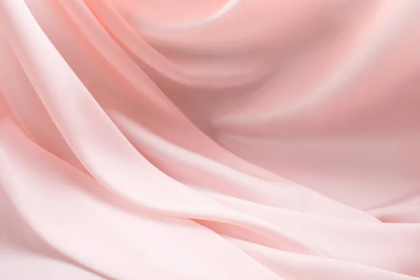 Шелковистый светло-розовый кремовый экру сложенный фон — стоковое фото