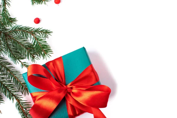 Fényes karácsonyi ajándék színes atlasz szalag és karácsonyfa ágak fehér háttér Stock Kép