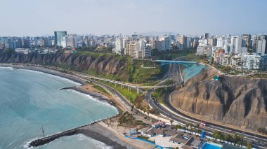 Lima, Peru 'daki otoyola Miraflores bölgesini bağlayan köprü manzarası, araba kullanan, binalar ve Pasifik Okyanusu.