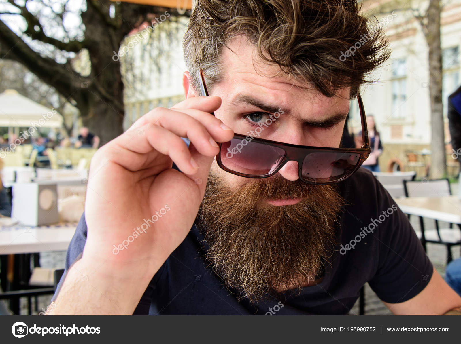 Male hipster shouting while wearing peace symbol sunglasses against black  background stock photo