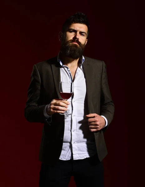 Человек в костюме тост с игристым бокалом красного вина — стоковое фото