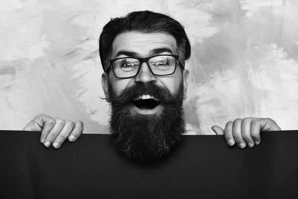 Homme barbu avec visage heureux dans des lunettes sur fond coloré — Photo