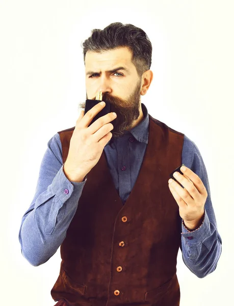 Brodaty mężczyzna wąchanie perfum z poważną twarz — Zdjęcie stockowe