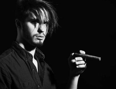 Sigara içen ciddi sakallı bir adam.