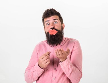 Fotoğraf booth eğlence kavramı. Parti sahne dudaklar, beyaz arka plan tutan adam. Hippi photo booth sahne, kopya alanı ile poz neşeli yüzünde bıyık ve sakal ile. Adam hava öpücük kırmızı dudaklar ile gönderme