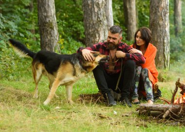 Alman çoban köpeği olan bir çift şenlik ateşinin yanında oturuyor..
