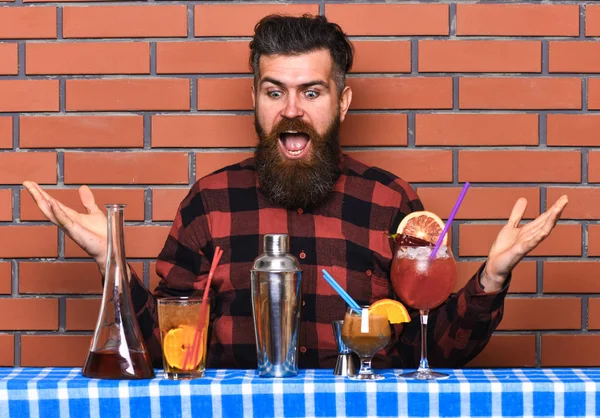 アルコール飲料のコンセプトです。レンガ壁の背景に格子縞のシャツの男は、飲み物を準備します。長いひげと口ひげアルコール カクテルを作る準備ができて興奮している顔にスタイリッシュな髪とバーマン — ストック写真
