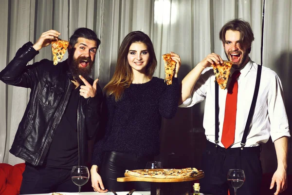 Felices amigos comiendo sabrosas rebanadas de pizza con los pulgares hacia arriba gestos — Foto de Stock