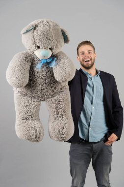 Gri oyuncak ayı mutlu adam. Büyük hayvan oyuncak maço gülümsemeyle. Hediye ve mevcut kavramı. Moda ve stil. Doğum günü veya yıldönümü ve tatil kutlama.