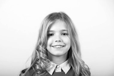 Gülümseyen tatlı yüzlü kız. Turuncu arka planda kıvırcık sarı saçlı çocuk. Mutlu çocukluk kavramı. Bak, tarz, saç stili. Güzellik, gençlik, moda.