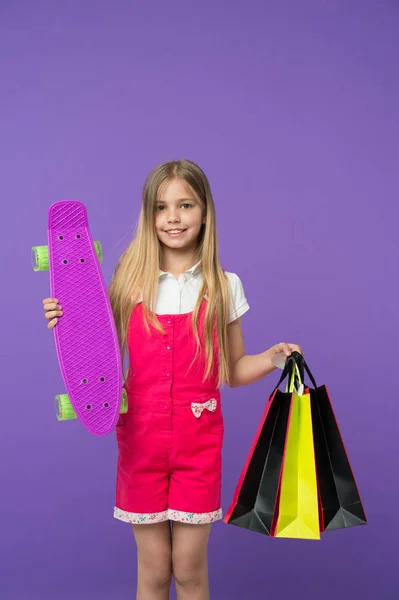 Gelukkig Meisje Met Skate Board Boodschappentassen Violette Achtergrond Kleine Glimlach — Stockfoto