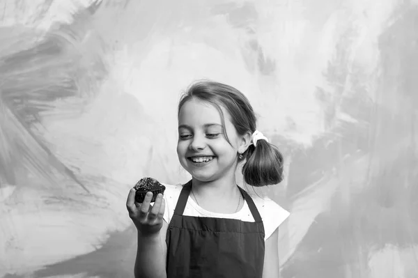 幸せな子供は ケーキと笑顔します カップケーキを食べる女子高生 パンやおいしいパン屋さん カラフルな抽象的な壁に赤シェフ エプロン赤ちゃん料理 健康食品とダイエットの概念 — ストック写真