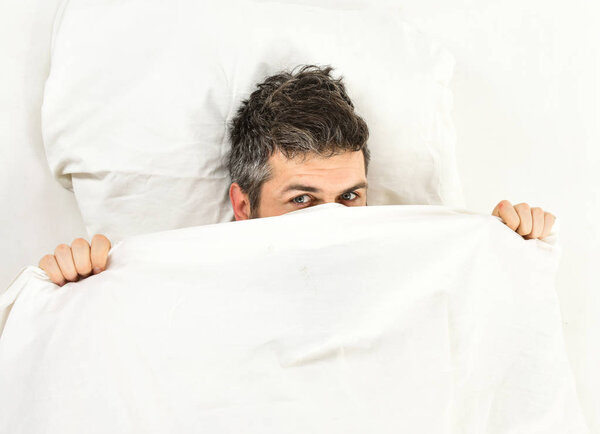 Sleepyhead concept. Man with sleepy face lies on pillow