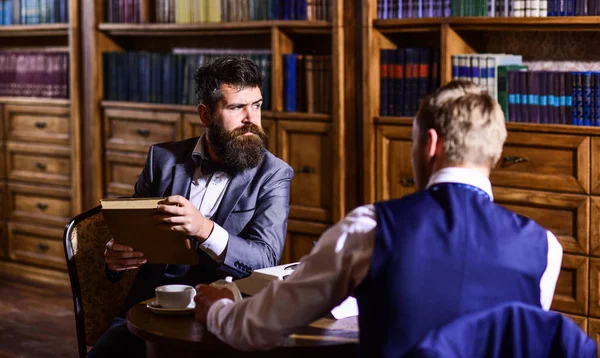 Amici seduti su poltrone in biblioteca, stile vintage. — Foto Stock