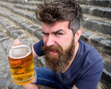 Adam soğuk fıçı bira ile dinlenme. İçecek kadar yükselterek hippi neşeli yüz açık, bira içiyor. Şerefe kavramı. Sakal ve bıyık tutan cam taş merdivenle oturur iken bira ile olan adam