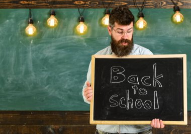 Geri okul kavramı. Kara tahta ile cümle içinde yazılı okula engel gözlük öğretmen. Sakal ve bıyık sürpriz yüz memnuniyetle öğrencilerin, kara tahta arka plan ile adam