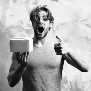 Kafkas sakallı seksi maço adam yemek kutusu tutuyor.