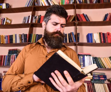 Adam meşgul düşünceli yüz kitap okumak, kitap rafı arka plan üzerinde. Öğretmen ya da sakal Kitaplığı'nda eğitim ile öğrenci. Bilim adamı kitap keşfetmek ile meşgul. Eğitim ve bilim kavramı