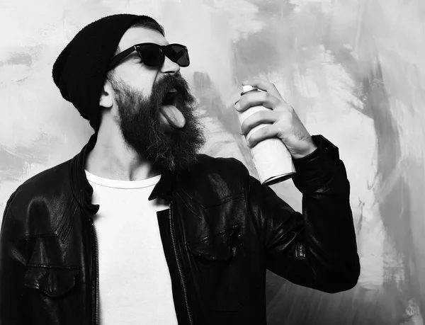 Bearded brutal caucasian hipster holding spray paint — Stock Photo, Image