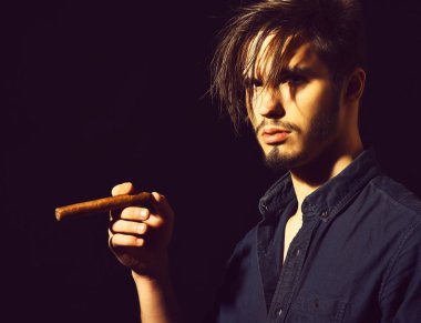 Sigara içen ciddi sakallı bir adam.