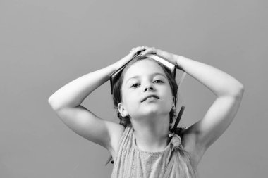 Elleri ile kafasına açık kitap kız havaya