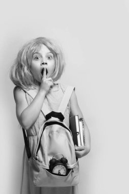 Çalar saati ve kitapları olan bir çocuk. Okul konseptine dönelim.