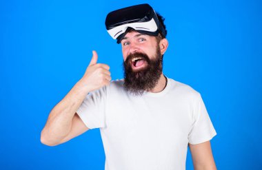 Sakal ve bıyık Vr gözlük, mavi arka plan ile olan adam. VR teknolojisi kavramı. Mutlu yüz hipster jest Yaşasın gösterir. Adam Vr gözlük veya baş ile görüntü monte