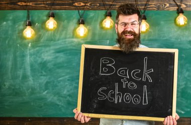 Sakal ve bıyık arka plan kara tahta üzerinde mutlu yüz memnuniyetle meslektaşları, adam. Gözlük öğretmen okul için başlıklı yazı tahtası tutar. İşe Alım öğretmenler kavramı