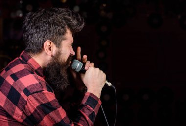 Yetenekli vokalist kavramı. Gergin yüz adam mikrofon, şarkı şarkı, siyah arka plan, kopya alanı tutar. Müzisyen, şarkıcı sakal ve bıyık tarafından Spot ışıklı