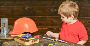 Yan görünümü çocuk kapma tornavida. Uzun metal civata ve vida somun ile oynayan çocuk. Resmi olmayan eğitim kavramı