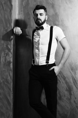 Stüdyo duvarında ciddi bir yüzü olan sakallı bir adam.