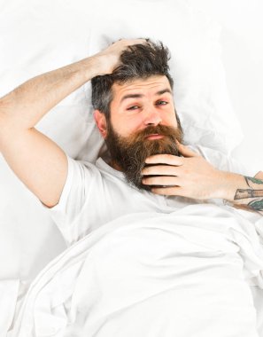 Dalgın yüz uyan, tırmalamak yatakta yatıyordu adam