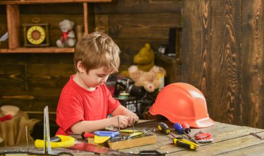 Çocuk Çocuk tamirci oynamak. Çocukluk kavramı. Çocuk şirin ve sevimli araçlarla builder veya repairer oynarken, onarma veya handcrafting. Evde araçlarında atölye ile yürümeye başlayan çocuk meşgul yüz üzerinde çalış