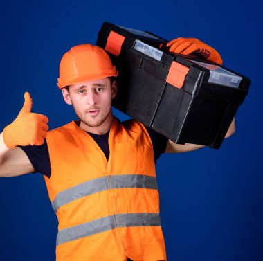 İşçi, repairer, tamirci, Oluşturucu emin yüz taşıyan araç omuz üzerinde. Kask, kask içinde adam araç kutusu tutar ve yukarı hareketi, mavi arka plan gösterir. Onarım istişare kavramı