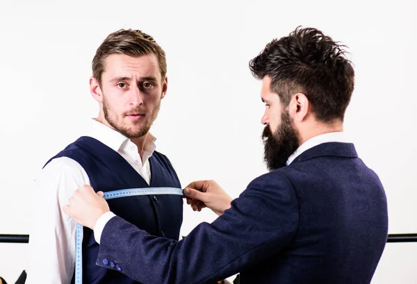Επιχειρηματίας, πελάτης σταθεί κοντά κρεμάστρα με κοστούμια, ενώ ράφτη εργασίας. — Φωτογραφία Αρχείου