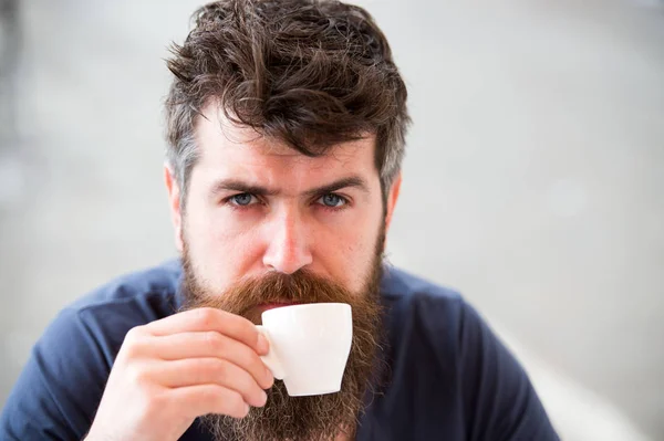 Kaffeepause-Konzept. Mann mit langem Bart sieht ruhig und entspannt aus. Mann mit Bart und Schnurrbart auf ruhigem, entspanntem Gesicht, heller Hintergrund, defokussiert. bärtiger Mann hält Espressotasse, trinkt Kaffee — Stockfoto