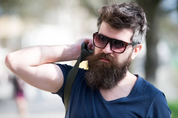 Hipster hombre con barba elegante y bigote caminando en la ciudad. Retrato de primer plano del joven guapo en gafas de moda al aire libre — Foto de Stock