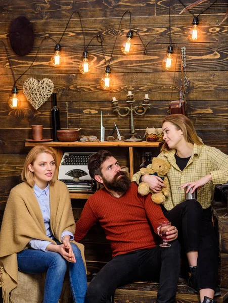 Hombres y mujeres con caras felices discutiendo y bebiendo vino caliente. Concepto de almas gemelas. Los amigos se divierten, hablan y beben bebidas calientes en el interior de madera. Los amigos pasan el ocio en el interior acogedor —  Fotos de Stock