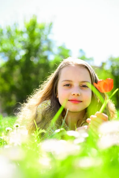 背景には、デフォーカスの自然草の上に横たわる少女。子供は、草原に横たわっている間春の晴れた日を楽しみます。季節性アレルギーの概念. — ストック写真