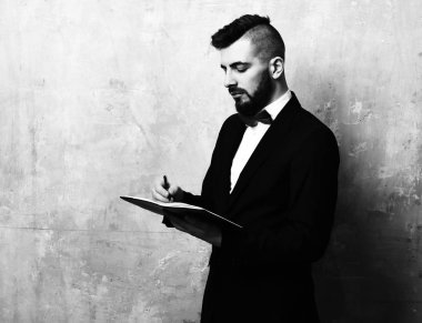 Ofis Yöneticisi sakal ve klasik takım elbise ile organizer içinde yazar