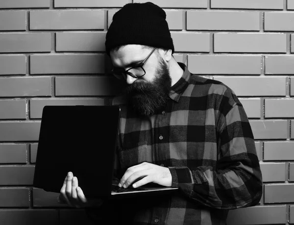 Barbudo brutal caucasiano hipster segurando laptop — Fotografia de Stock