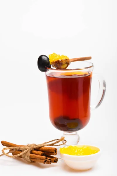 Healing drink concept. Glass with mulled wine or hot tea with grape, cinnamon and honey on white background, close up. Hot wine or mulled wine with spices and honey — Stock Photo, Image