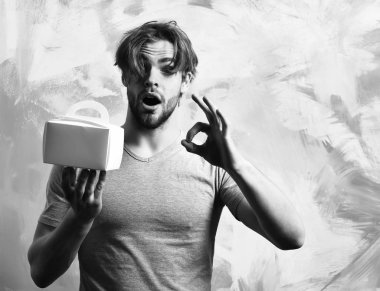 Kafkas sakallı seksi maço adam yemek kutusu tutuyor.