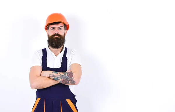 Home renovation concept. Brutal boss standing with arms crossed at his chest. Isolated bearded man in orange helmet on white background — Stock Photo, Image